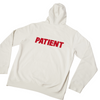 White hoodie with the word PATIENT printed in red on the back