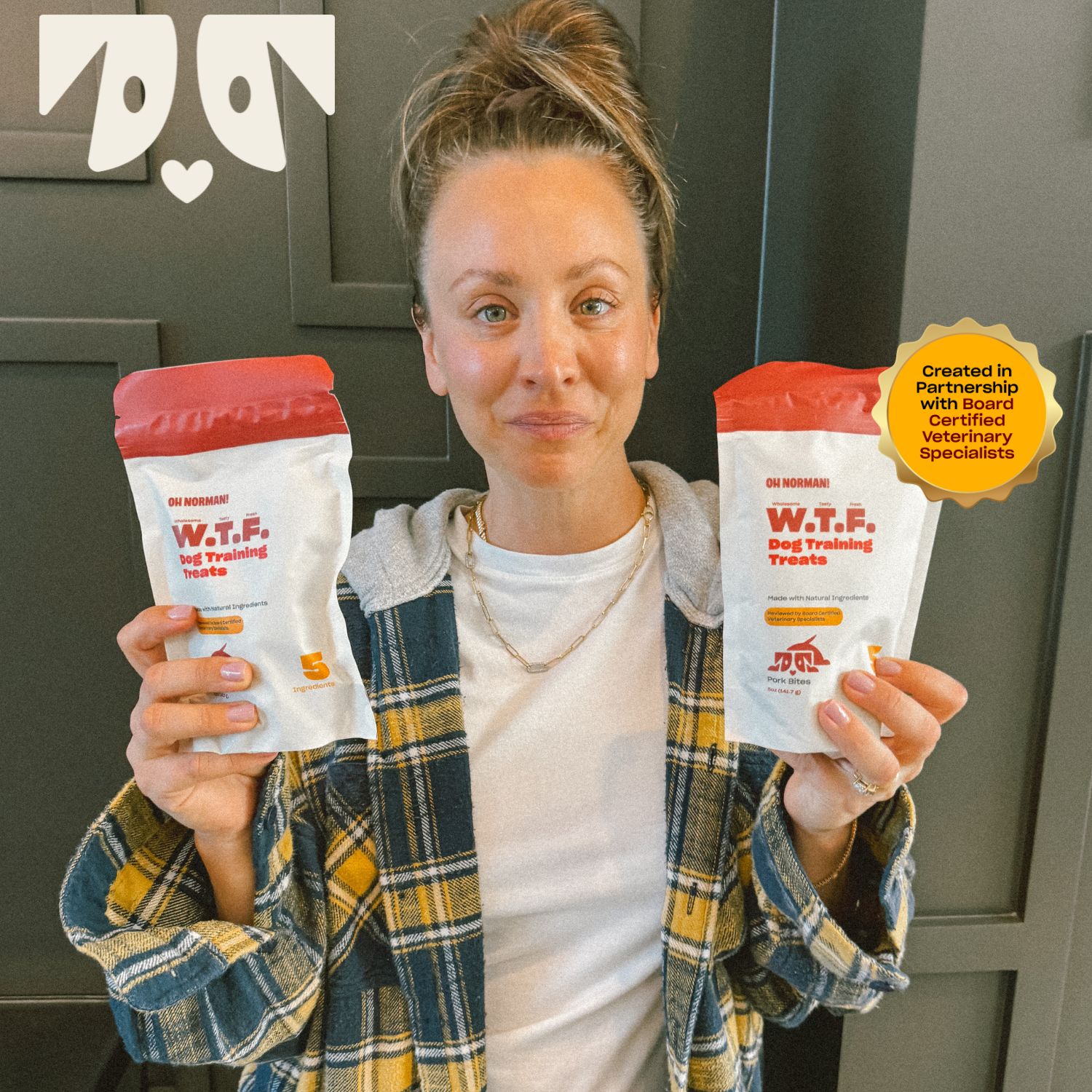 Kaley Cuoco holding two containers of WTF Dog Training Treats